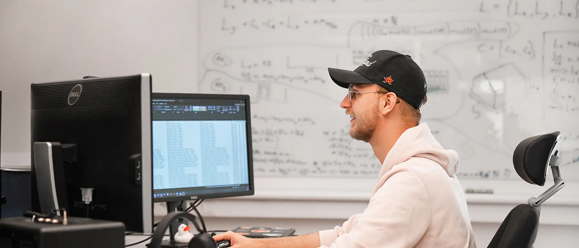 Programmerare som sitter framför datorn och ler