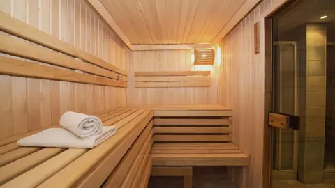 Bastu med en handduk liggandes på andra bänkraden