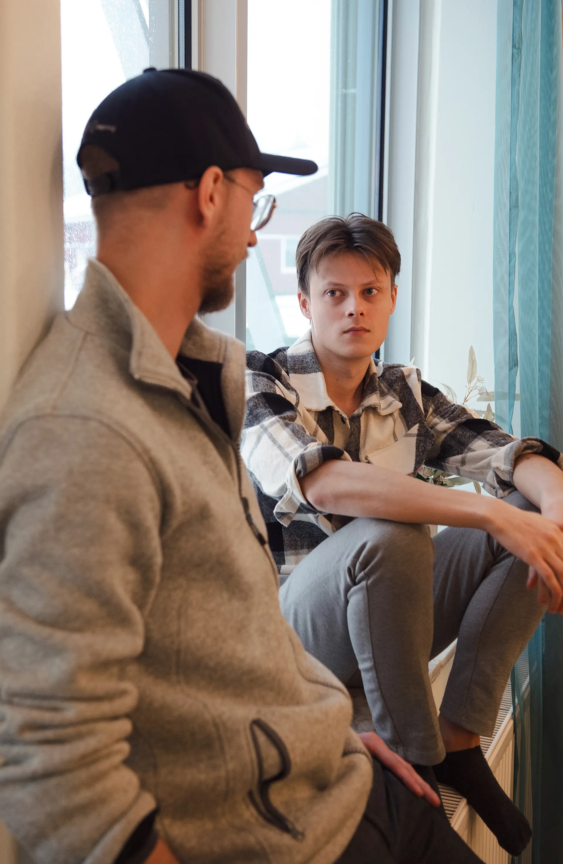 Två killar som sitter och pratar med varandra