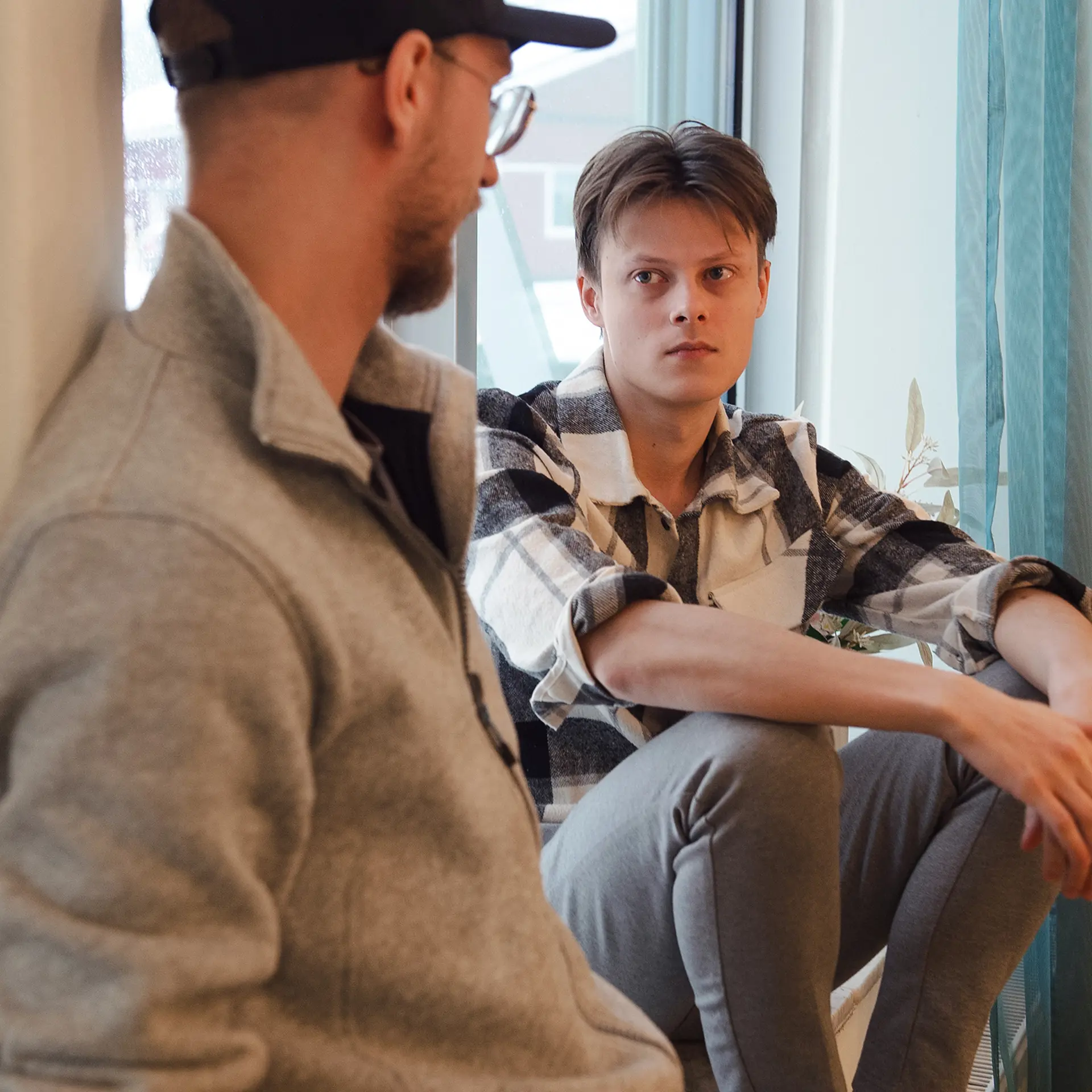 Två killar som sitter och pratar med varandra