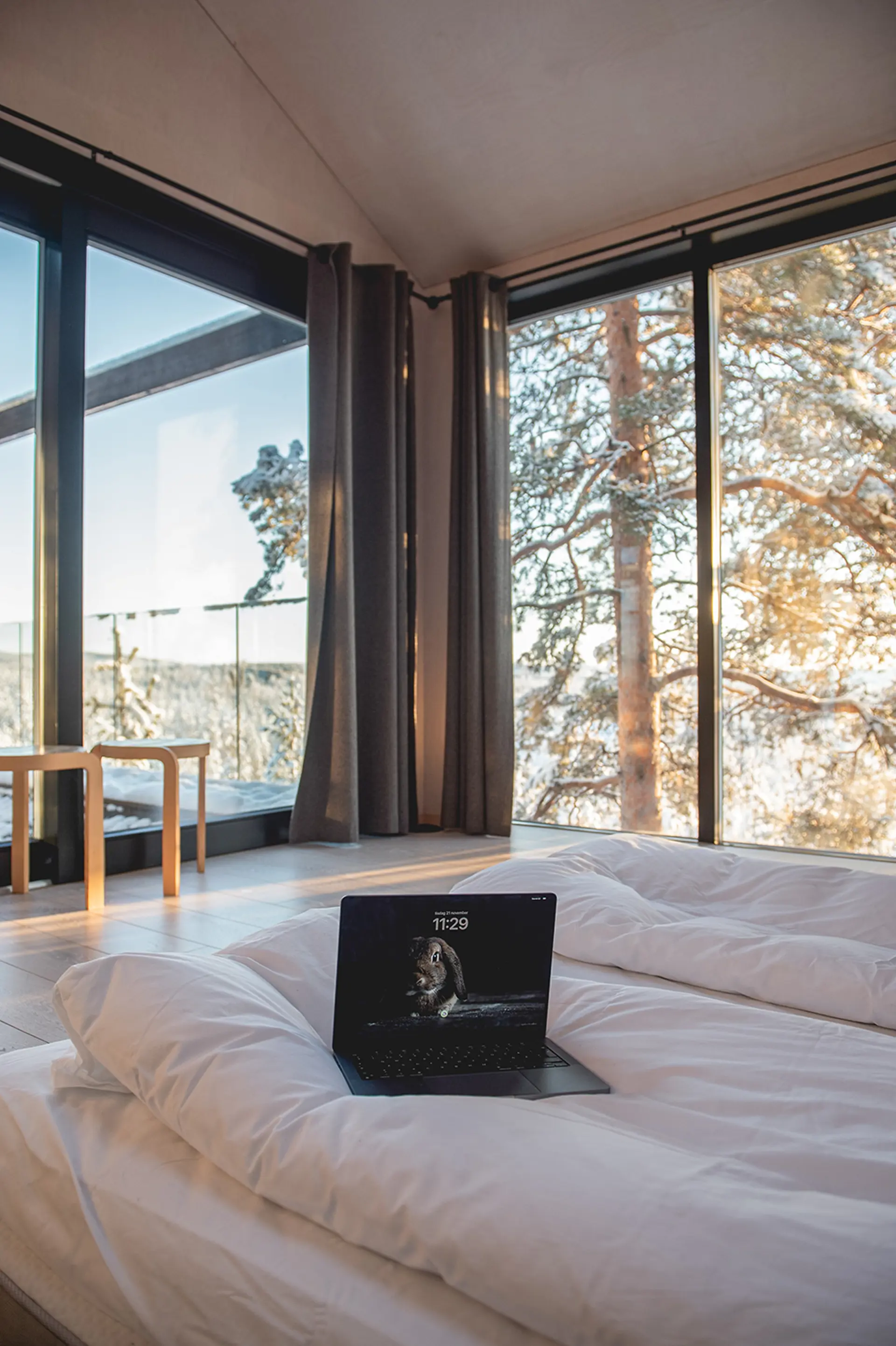 Hotellrum med sängar i förgrunden och utsikt över snötäckta träd