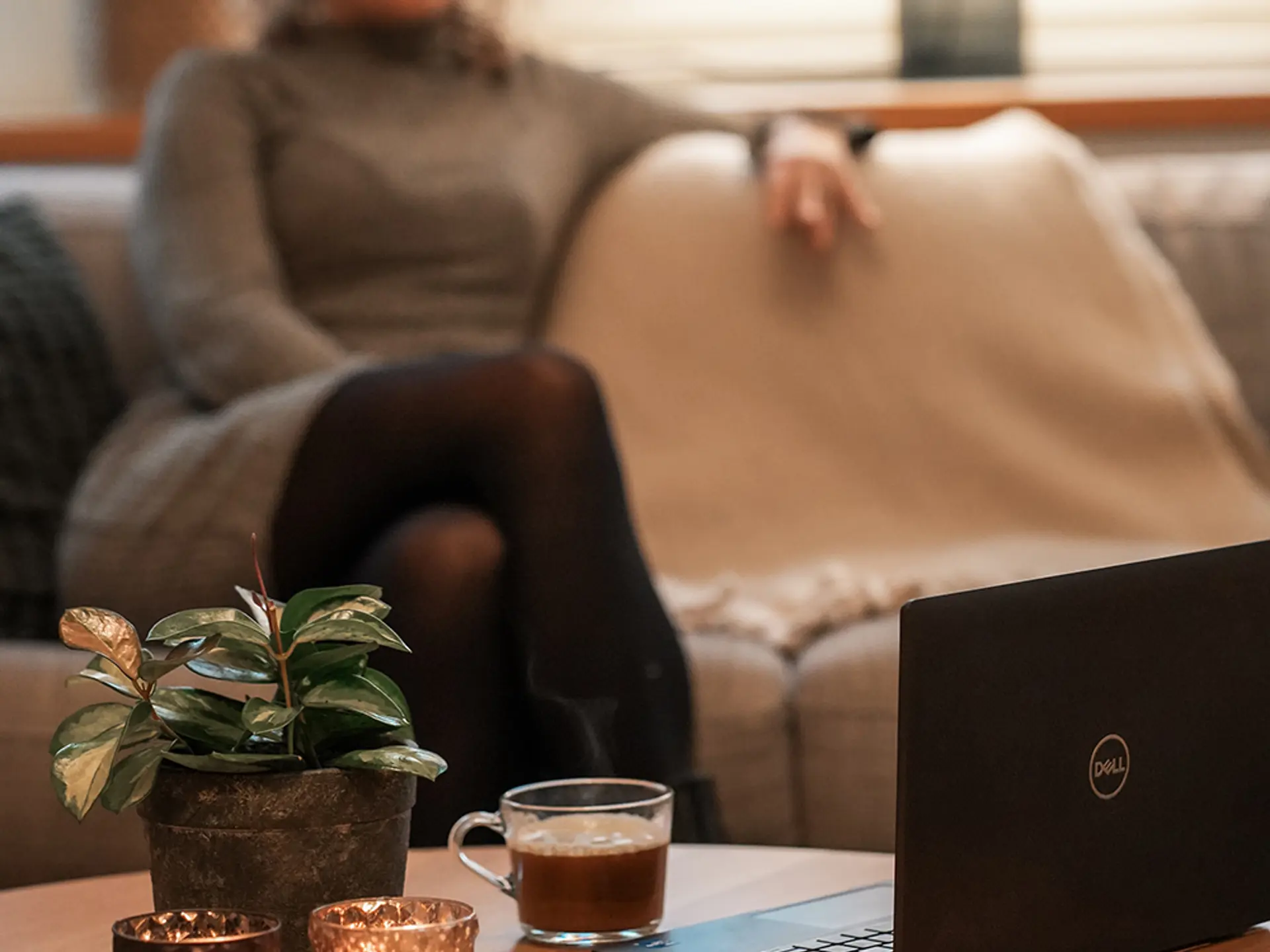 Kvinna som sitter i en soffa i bakgrunden
