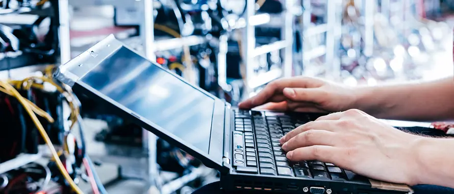 En person som sitter framför en dator i serverhall