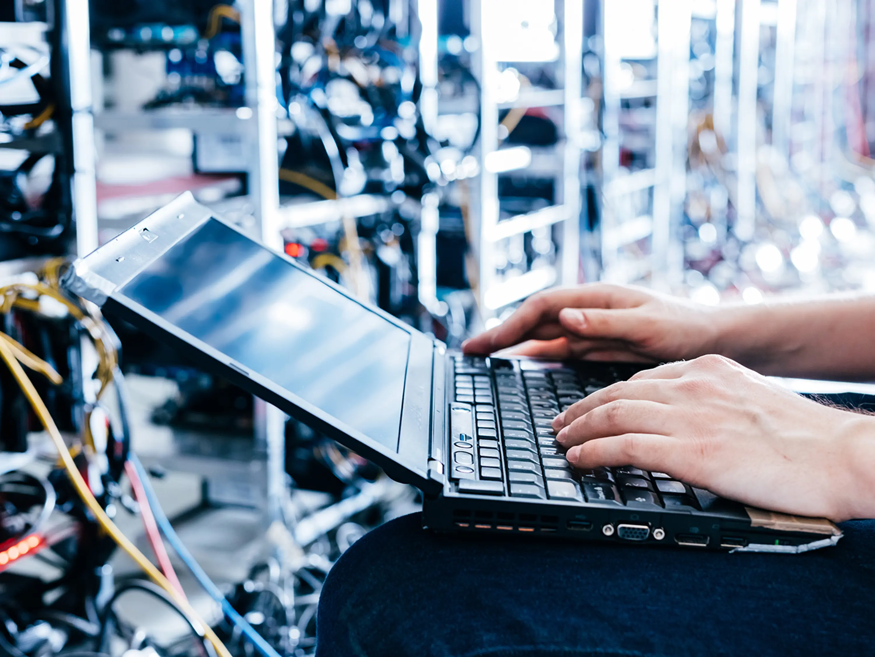 En person som sitter framför en dator i serverhall