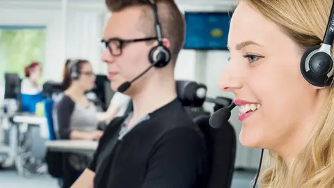 En manlig och en kvinnlig telefonist sittandes bredvid varandra