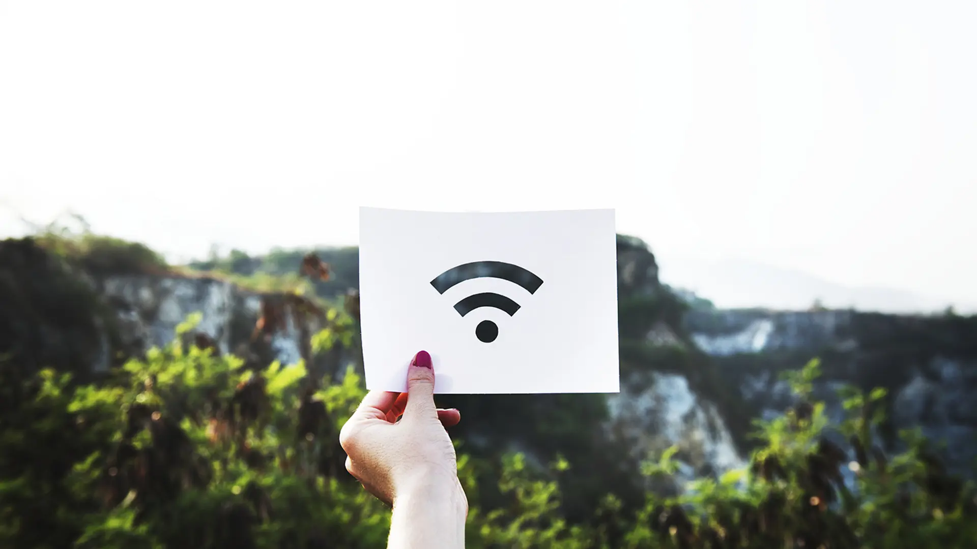 En tjej som håller upp en bild på en wifi symbol