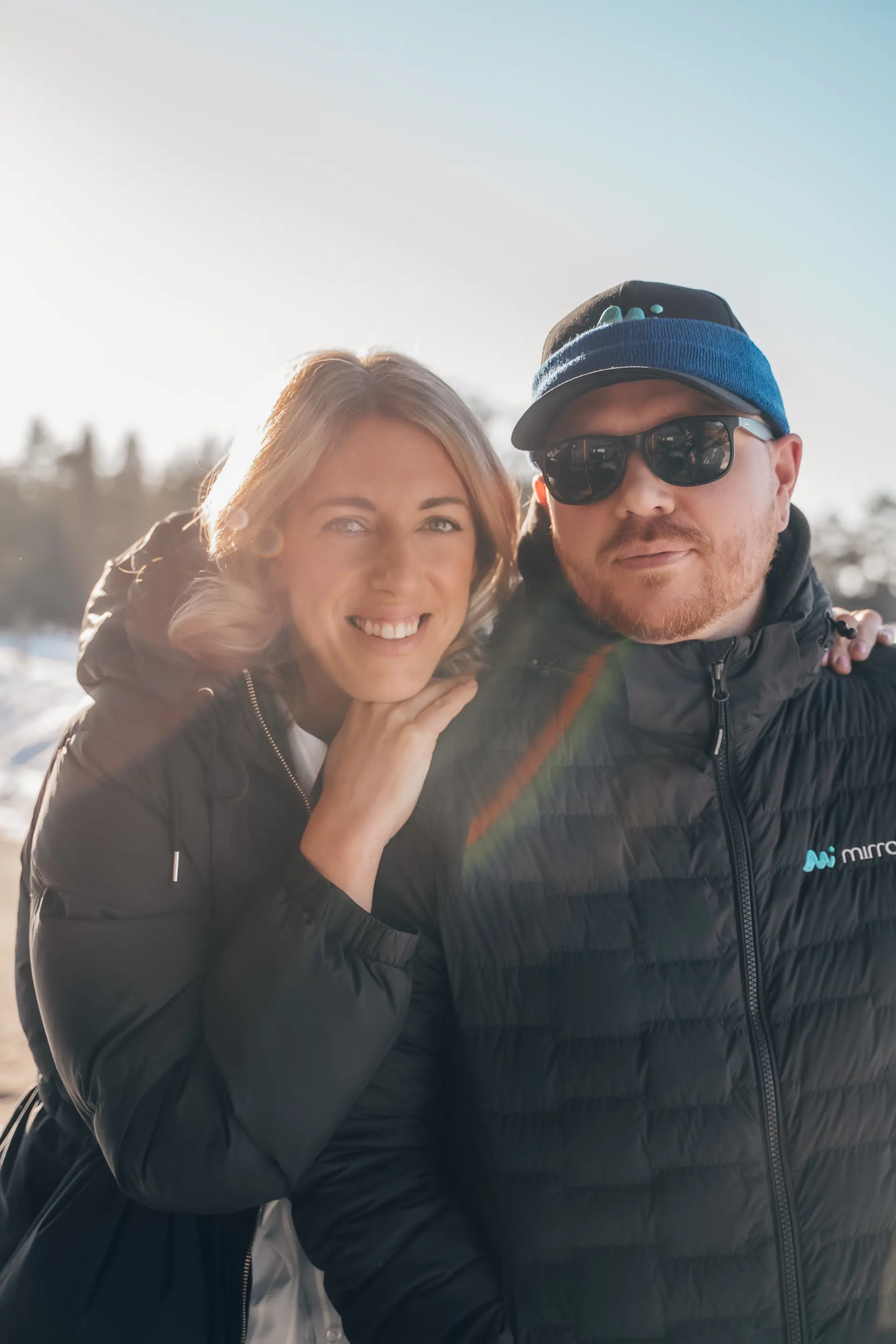 En kille i solglasögon och en tjej som ler mot kameran